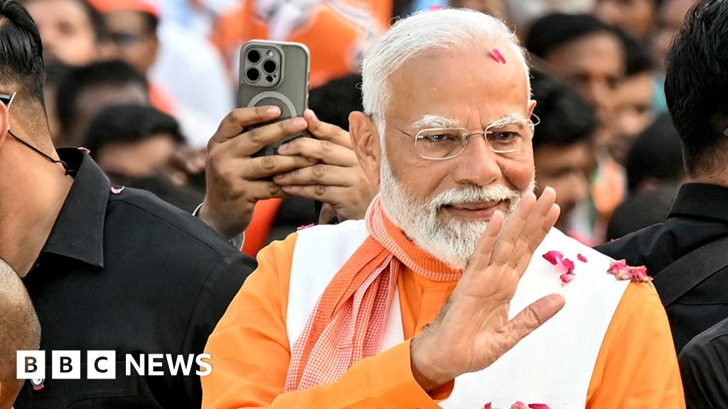 India's Prime Minister Narendra Modi waves to supporters during a roadshow in Varanasi