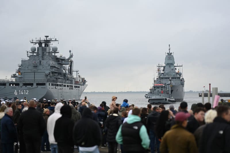 Numerous members watch the German frigate Hessen (R) arrive amid light rain. Lars Penning/dpa