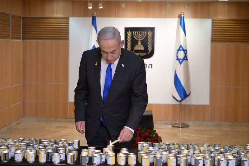 Israeli Prime Minister Benjamin Netanyahu lights a candle during a ceremony marking the Holocaust Remembrance Day at the Knesset. Amos Ben-Gershom/GPO/dpa