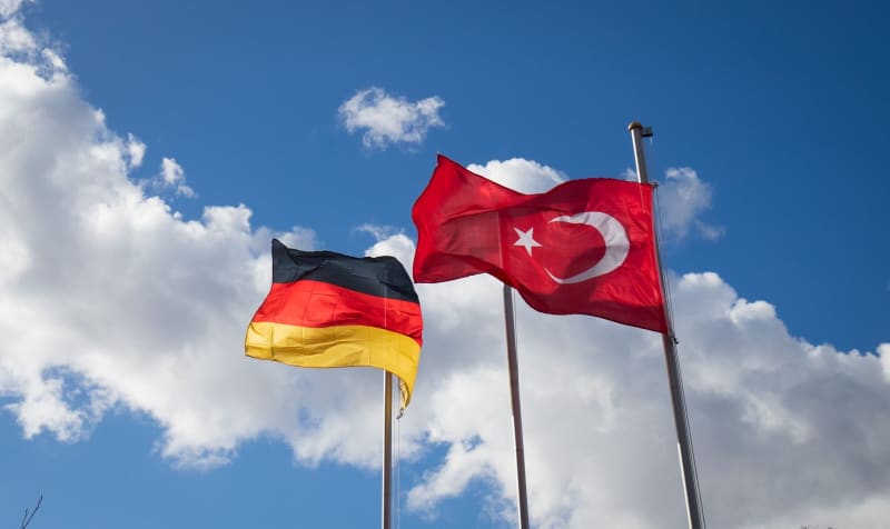 The German and Turkish flags can be seen on flagpoles in front of a mosque. Christian Charisius/dpa