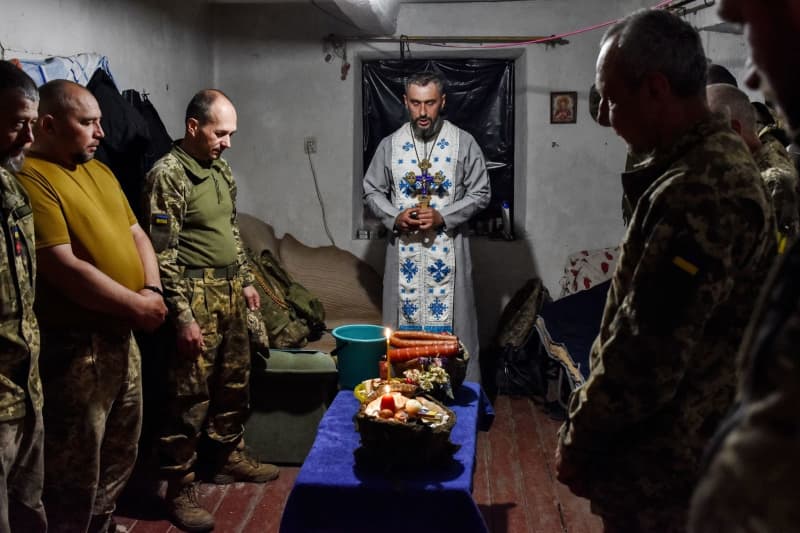 A chaplain (C) blesses servicemen of Ukraine's 141st separate infantry brigade on Easter Eve near the frontline in Zaporizhzhia region. Andriy Andriyenko/SOPA Images via ZUMA Press Wire/dpa