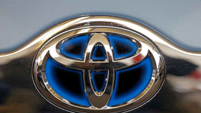 This Feb. 14, 2013, file photo shows the Toyota logo on the trunk of a Toyota automobile at the Pittsburgh Auto Show in Pittsburgh. Toyota Motor Corp. and Mazda stopped the sale and delivery of some vehicles after Japan’s transport ministry found irregularities in applications to certify certain models amid a growing auto safety scandal.