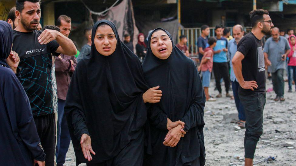 Palestinians react after an Israeli strike on a UN school in Nuseirat refugee camp, in the central Gaza Strip (6 June 2024)