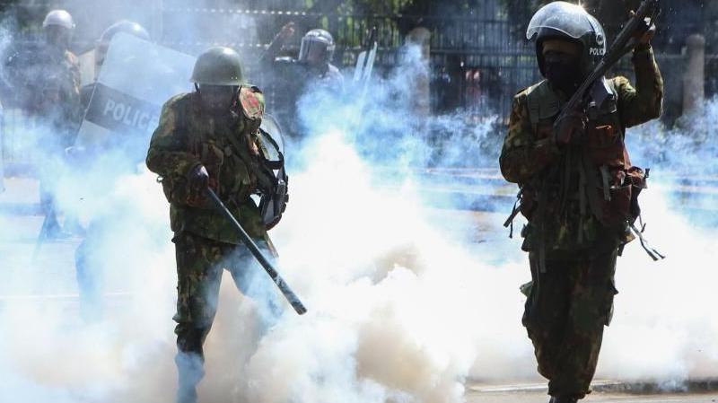 Armed members of the Kenyan security forces fire teargas at demonstrators during a protest near the Parliament against tax hikes, in Nairobi, Kenya, 25 June 2024