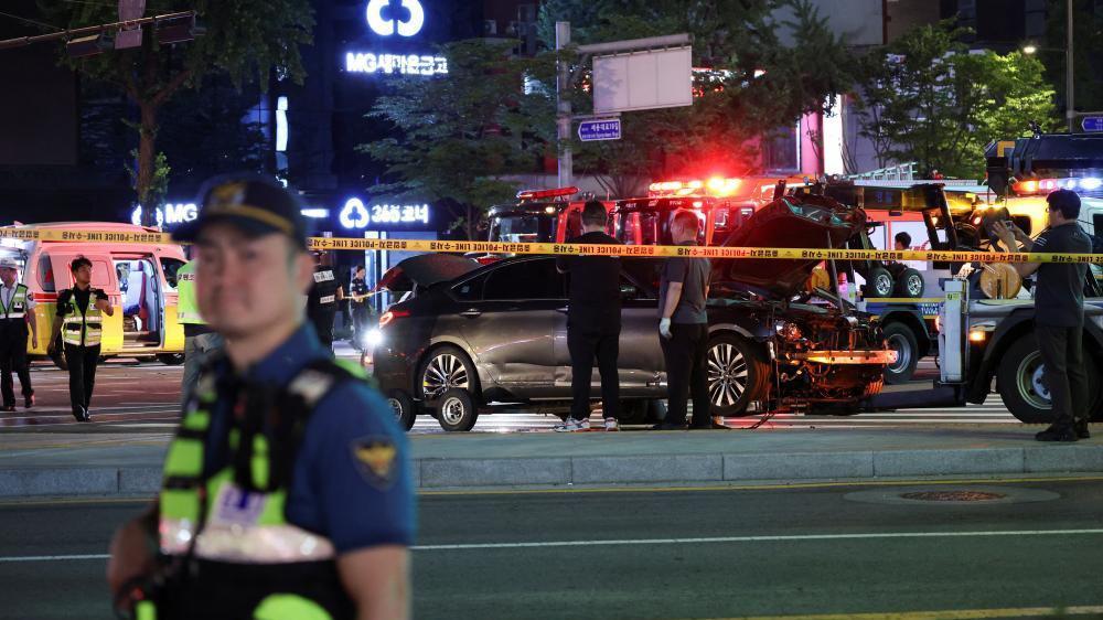 Police and rescuers stand next to a car involved in accident that resulted in several people killed and injured in central Seoul, South Korea July 1, 2024.