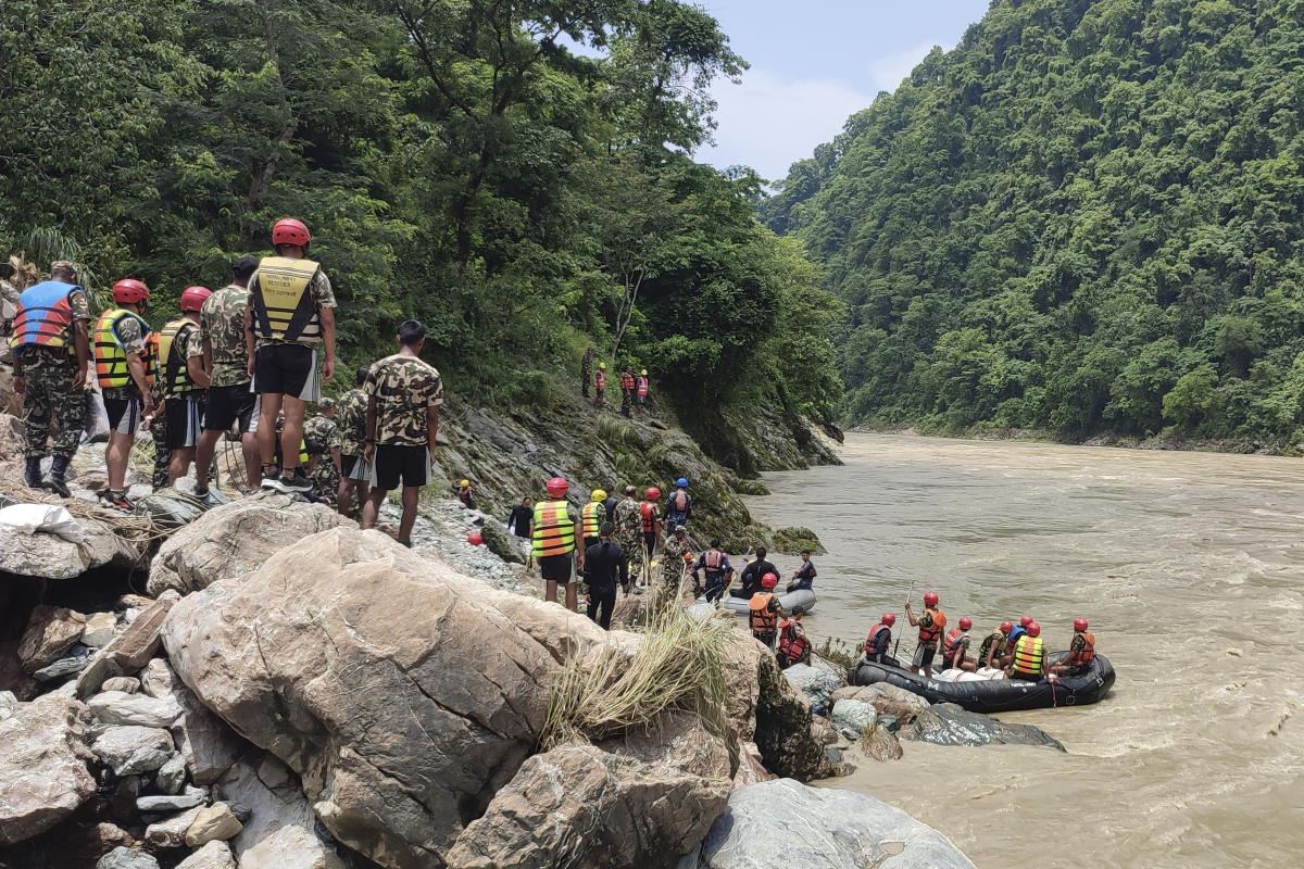 Rescuers recover the first body from two buses swept by a landslide and fell into a river in Nepal