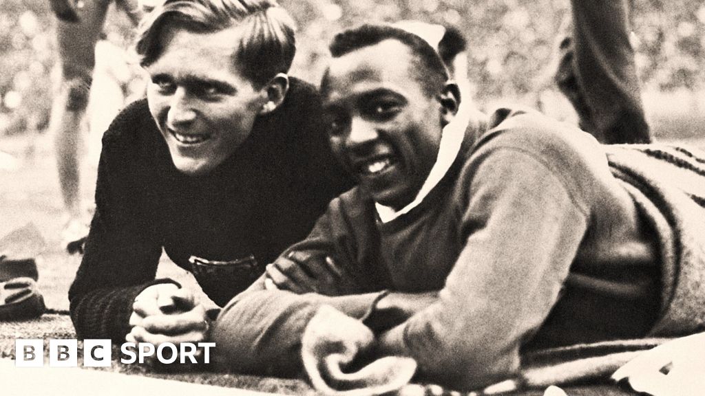 Luz Long and Jesse Owens pose at the side of the track at the 1936 Olympics in Berlin