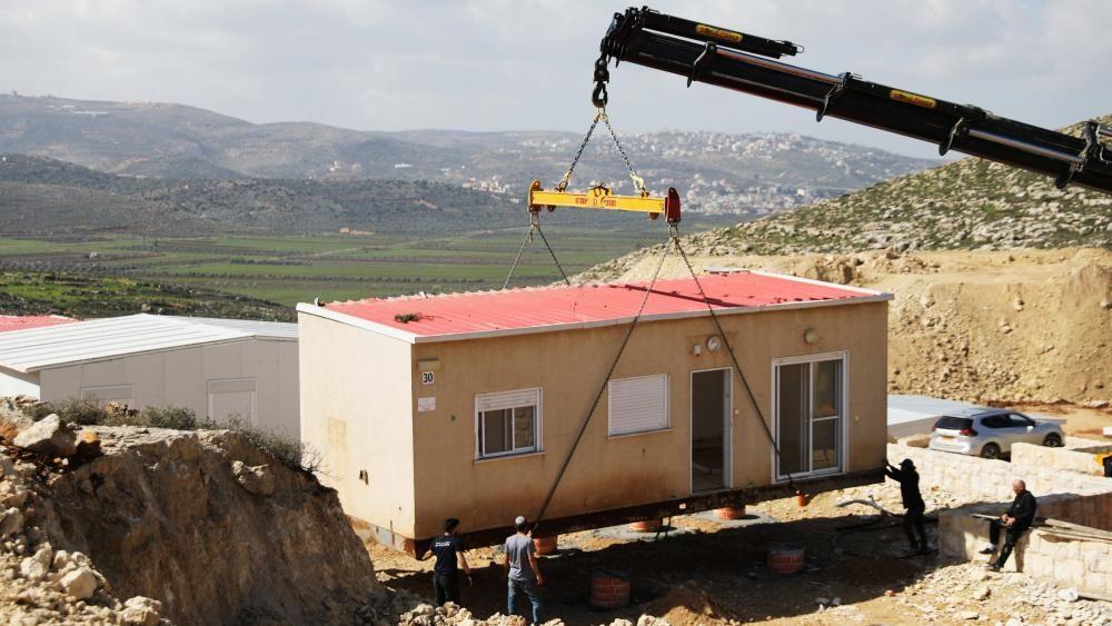 A crane lowers a caravan to the ground in the West Bank settlement of Amichai (file photo)