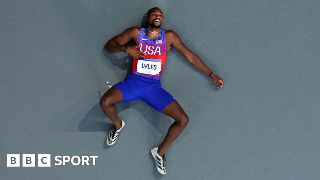 Noah Lyles lies on the track at the Stade de France