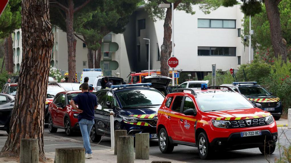 Law enforcement officers and firefighters stand in front of the synagogue building following the fire and explosion of cars in La Grande-Motte, south of France, on August 24, 2024.