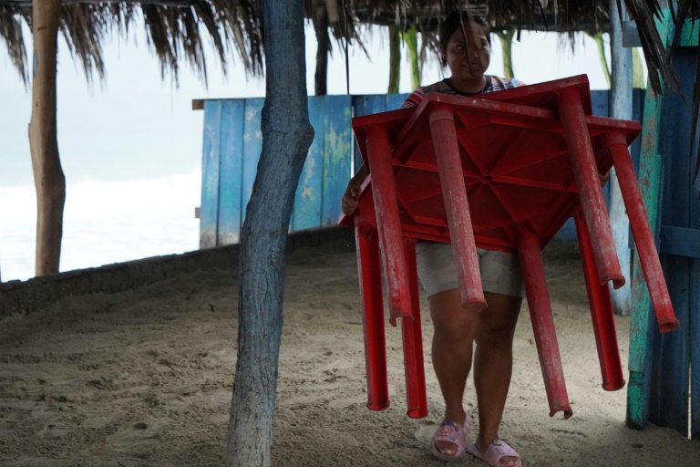 A woman brings tables in from the beach in southern Mexico ahead of the arrival of Hurricane John (RUSVEL RASGADO)