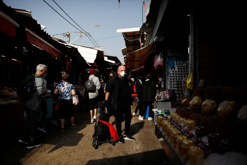 A man wearing a mask shops at a food market in Tel Aviv