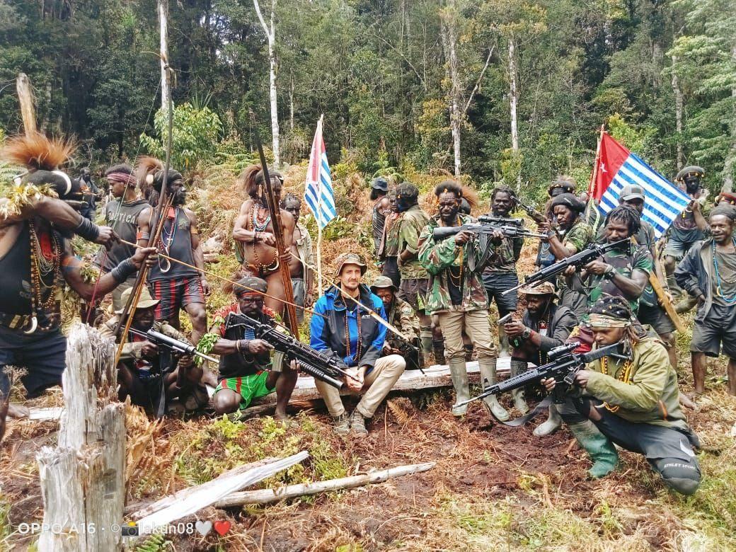 Philip Mehrtens sits between armed separatist fighters in Indonesia's Papua region.