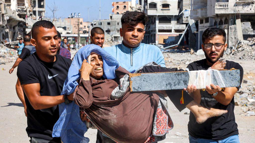 Men carry an injured woman out of Jabalia refugee camp, in the northern Gaza Strip (9 October 2024)