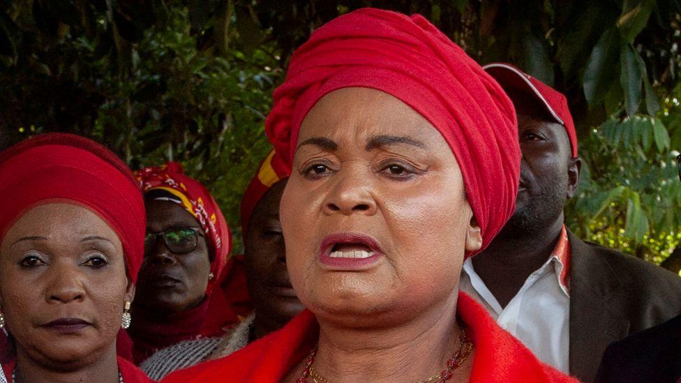 Archive headshot of Patricia Kaliati form June 2024 speaking while wearing a red head wrap.