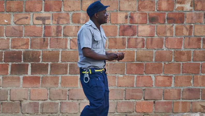 A Zimbabwean police officer walks towards a polling station during Zimbabwe's presidential and legislative elections in Bulawayo on August 23, 2023. Zimbabweans on August 23, 2023